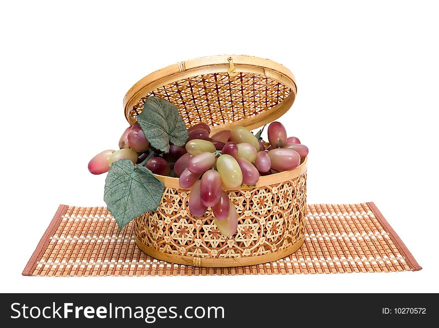 Bast basket with a grapes is photographed on the white background