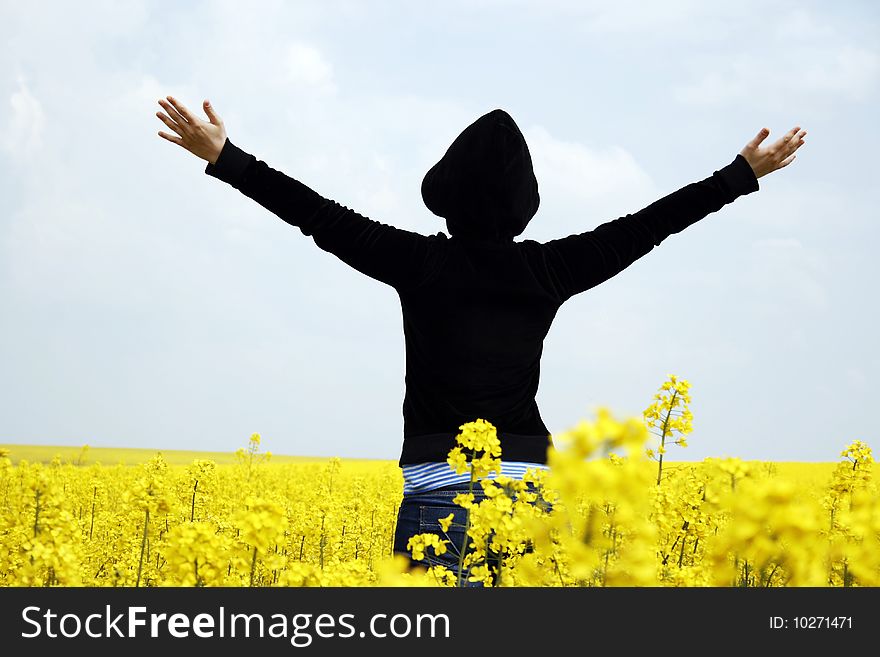 Young girl with hands raised against the sky in a field. Young girl with hands raised against the sky in a field