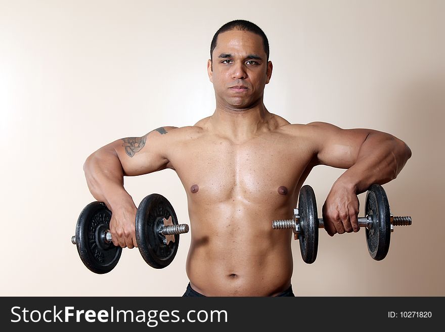 Muscular male body, lifting dumbbells