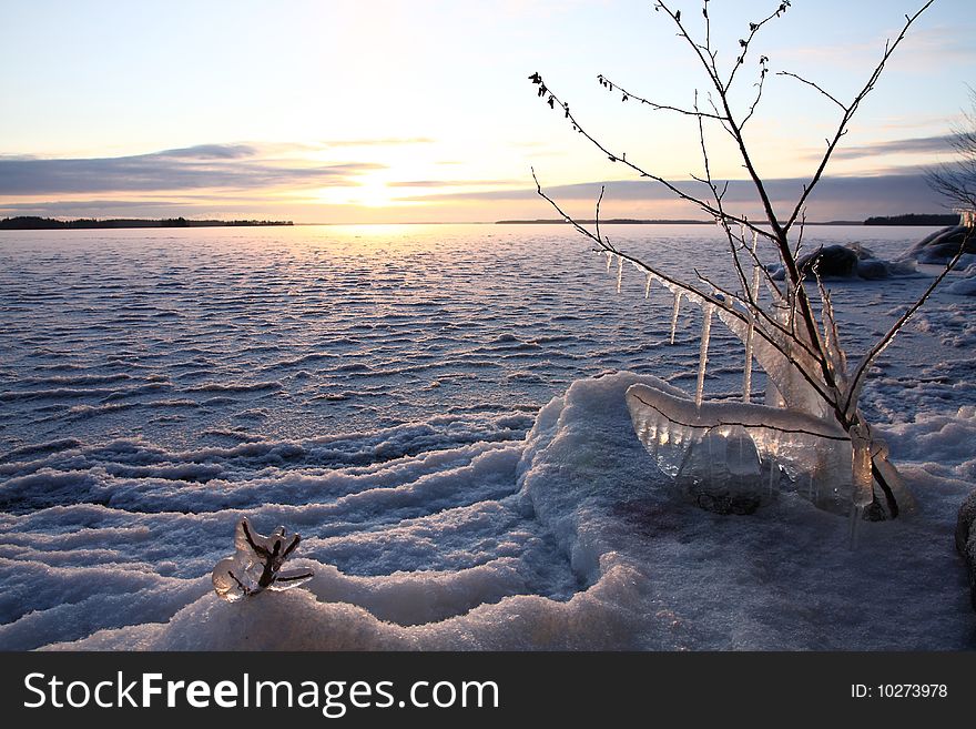 Sunset over frozen lake in winter, Finland