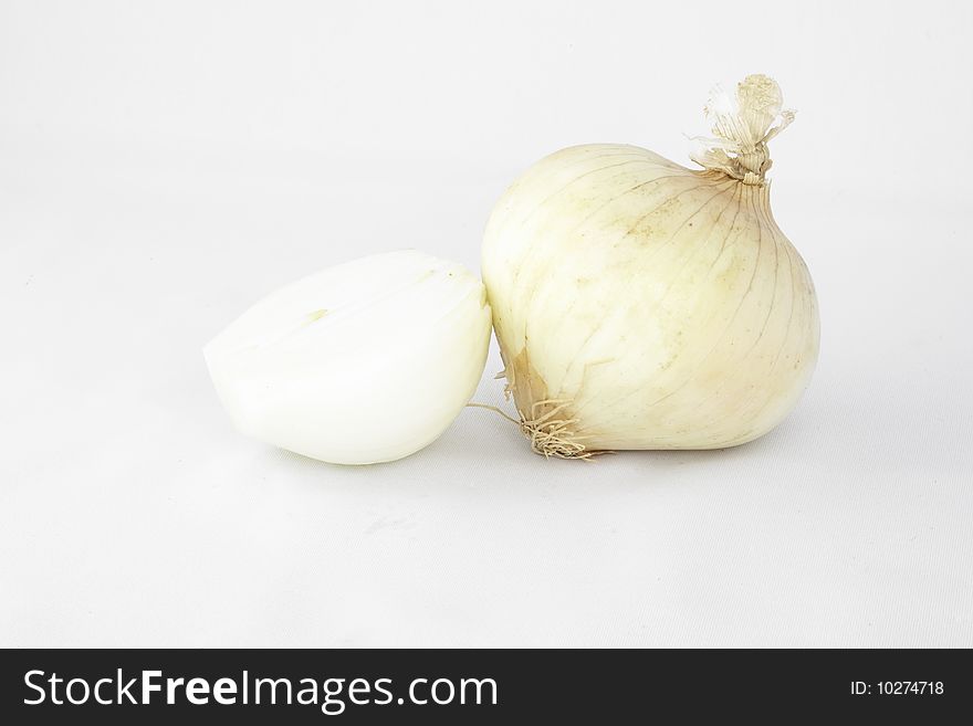 Two white cooking onions one is cut in half
