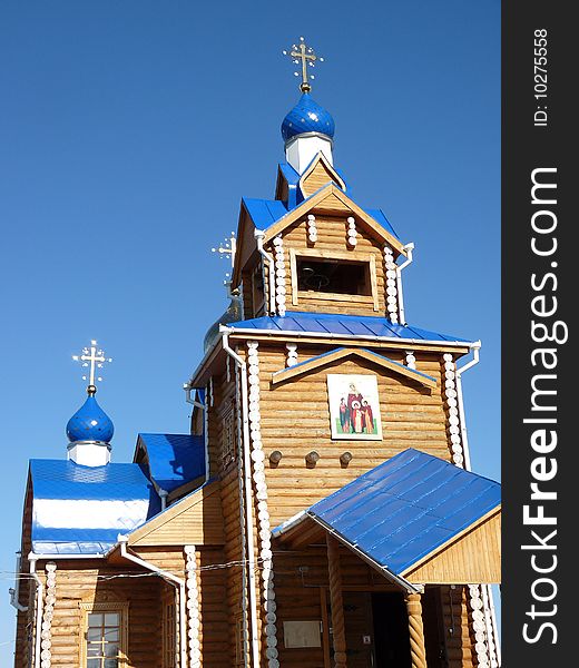 New wooden Orthodox temple (church) with blue roofs. New wooden Orthodox temple (church) with blue roofs.