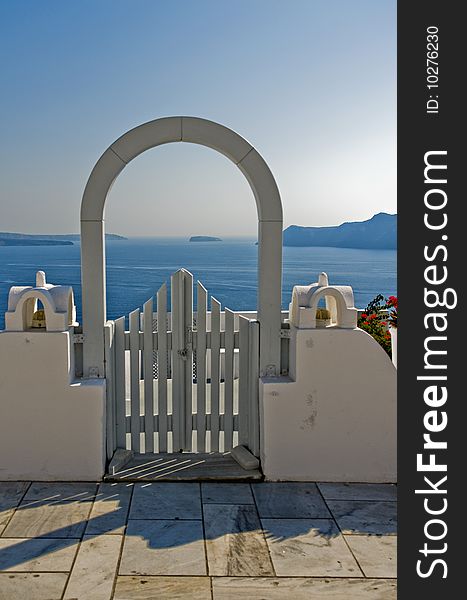 A lovely view of the ocean from a white arched gate. A lovely view of the ocean from a white arched gate