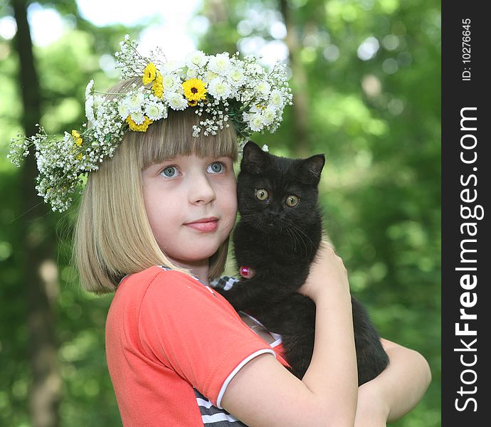 The girl with a black kitten in hands. The girl with a black kitten in hands.