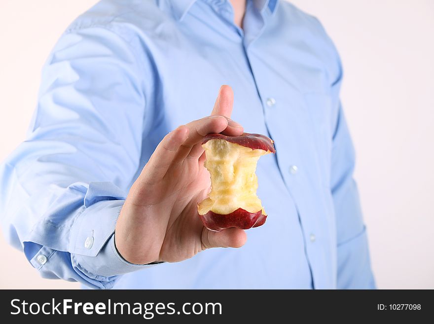 The man holds an apple core in hand