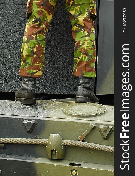 Legs of a soldier standing on a military vehicle. Legs of a soldier standing on a military vehicle