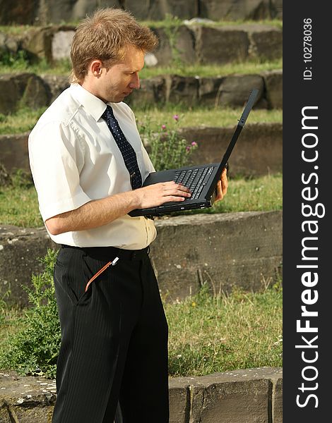 Businessman working on laptop computer outdoors. Businessman working on laptop computer outdoors