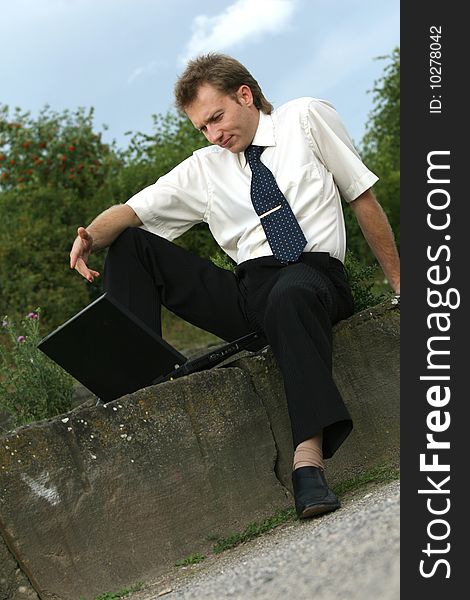 Businessman working with a laptop computer outdoor. Businessman working with a laptop computer outdoor