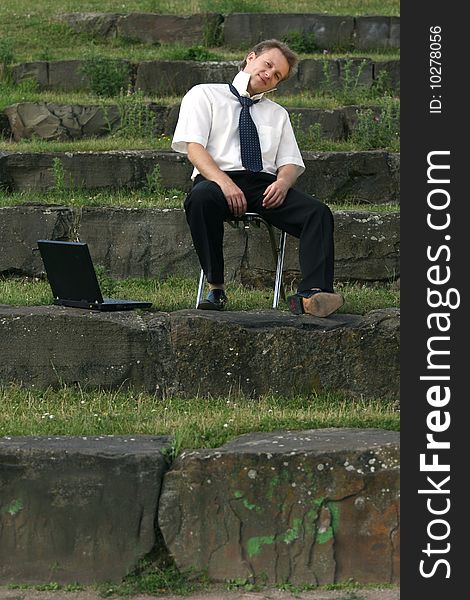 Relaxing businessman sitting on the steps with laptop. Relaxing businessman sitting on the steps with laptop