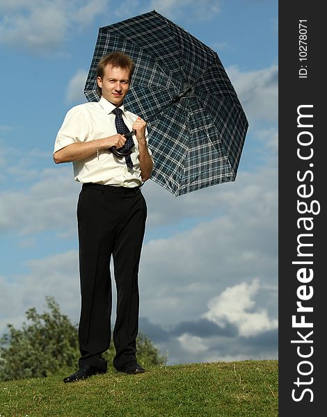 Businessman holding umbrella by good weather