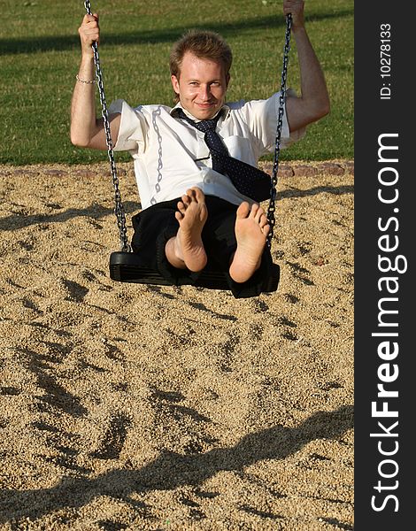 Businessman swinging at the playground