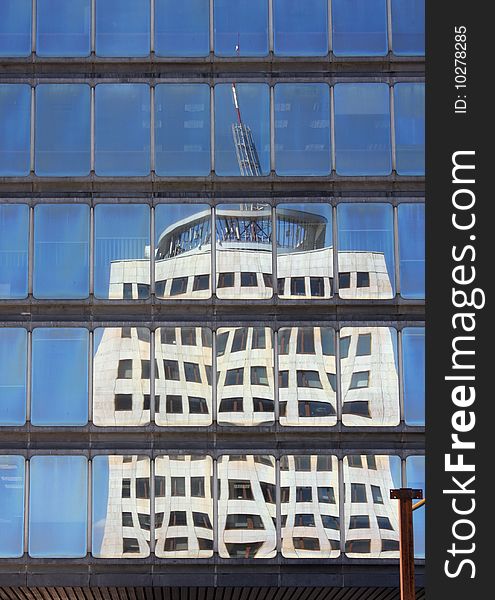 Reflection of skyscraper in windows of modern office building