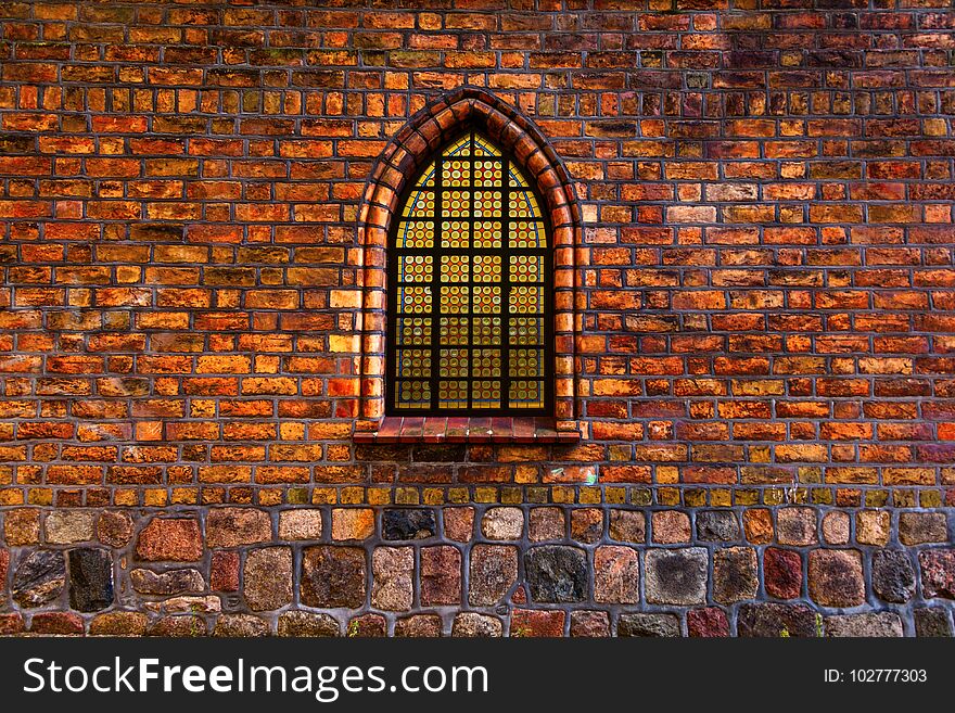 Composite image of stained glass window set in ancient window arch of an old church. Composite image of stained glass window set in ancient window arch of an old church