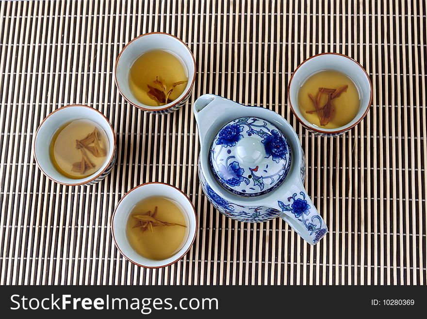 Blue and white porcelain pot and teacups in the bamboo background. Blue and white porcelain pot and teacups in the bamboo background.