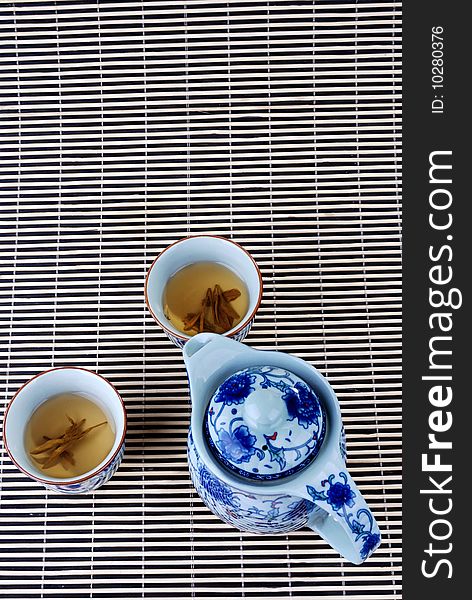 Blue and white porcelain teapot and teacups in the background of bambooã€‚