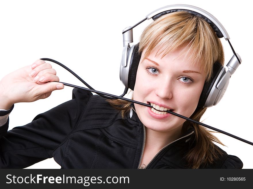 A girl plays with a cable of the earphones listening to the music. A girl plays with a cable of the earphones listening to the music