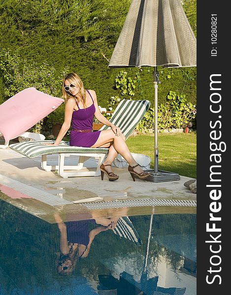 A young attractive woman standing by pool. A young attractive woman standing by pool