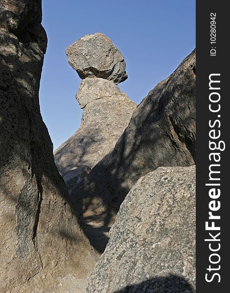 A volcanic boulder perches precariously on a column of rock. A volcanic boulder perches precariously on a column of rock.