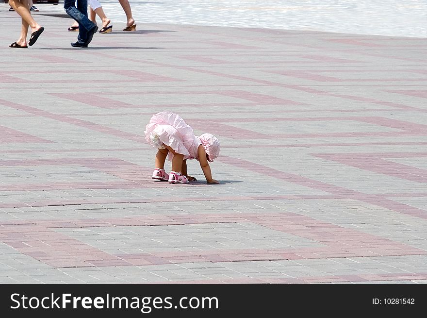 The little girl in a pink dress takes the first steps