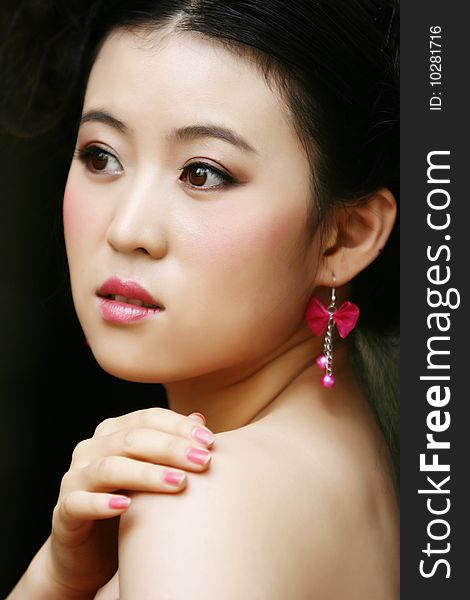 Chinese young lady wears a pink ear ring. Chinese young lady wears a pink ear ring