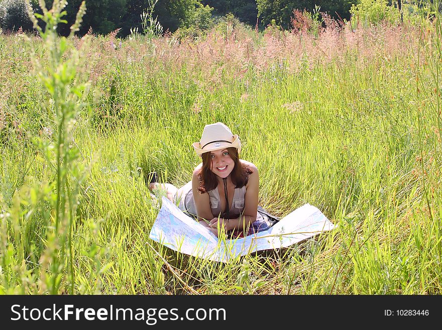 The girl on summer meadow with topographic map