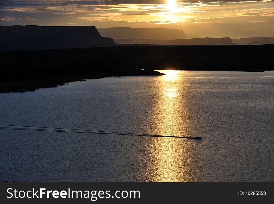 Solitary boat enjoys the sunrise at Lake Powell on the Utah/Arizona border - taken June 26 2009. Solitary boat enjoys the sunrise at Lake Powell on the Utah/Arizona border - taken June 26 2009