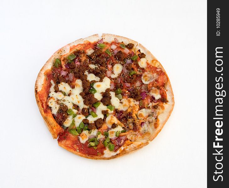 A pizza with spicy beef, green peppers and red onion isolated over a white tablecloth. A pizza with spicy beef, green peppers and red onion isolated over a white tablecloth