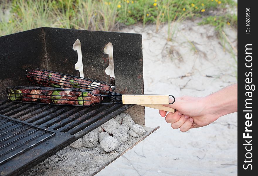 Grill meat cooking charcoal picnic beach hand. Grill meat cooking charcoal picnic beach hand