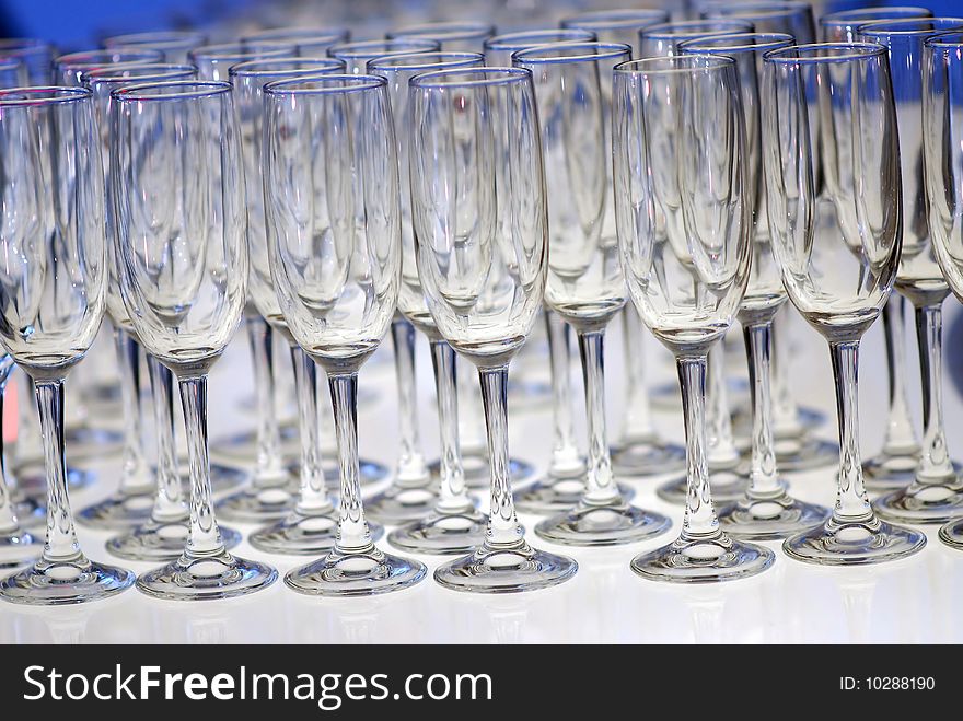 Glasses for champagne stand on a shone table