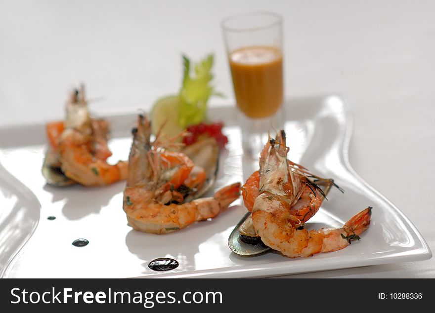 Shrimps and mussels with sauce on a white plate