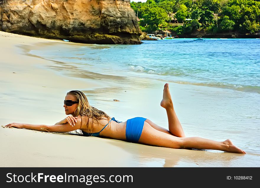 Blonde lady lying in water on the beach