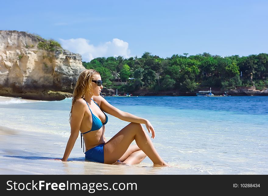 Blonde Girl Relaxing In Water On The Beach