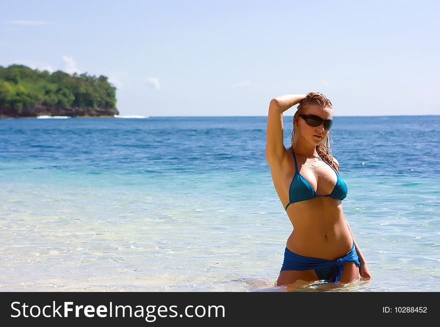 Blonde Girl Relaxing In Water On The Beach