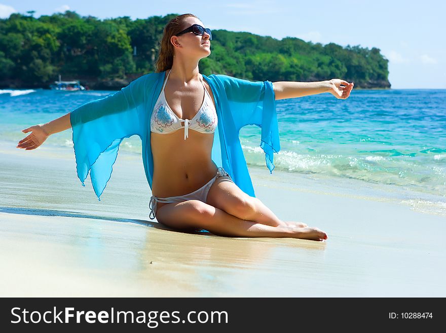 Beautiful brunette young girl relaxing on the sand beach on Bali island in Indonesia. Beautiful brunette young girl relaxing on the sand beach on Bali island in Indonesia