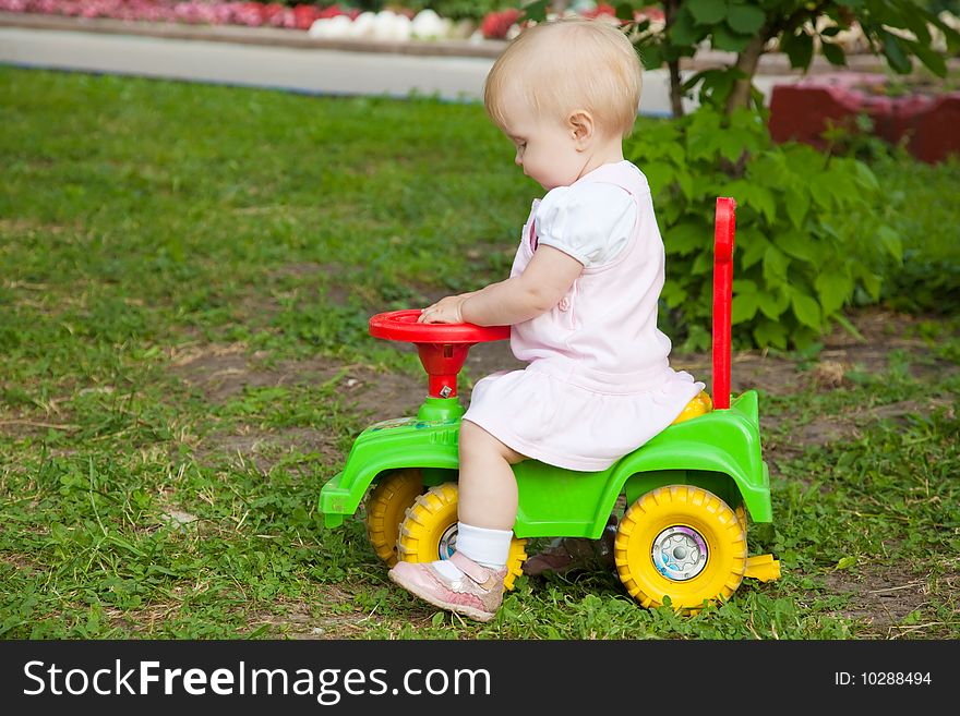 Little girl sitting on a green car