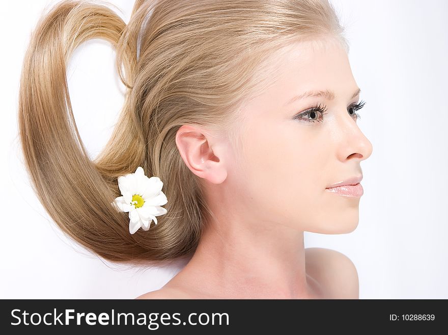 Close-up beautiful young fresh blonde lady relaxing with flower in her hair. Close-up beautiful young fresh blonde lady relaxing with flower in her hair