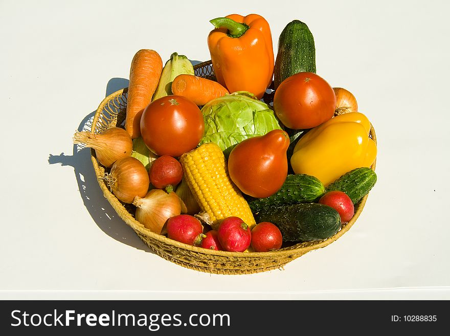 Basket with vegetables on white background