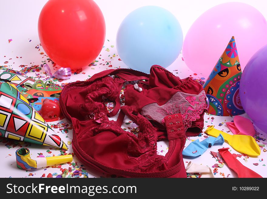 Ladies pants laying at a floor filled with party attributes, balloons and confetti. Ladies pants laying at a floor filled with party attributes, balloons and confetti