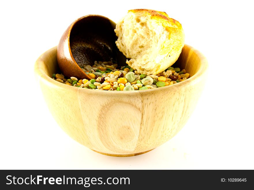 Wooden bowl of soup pulses with crusty bread on a white background. Wooden bowl of soup pulses with crusty bread on a white background