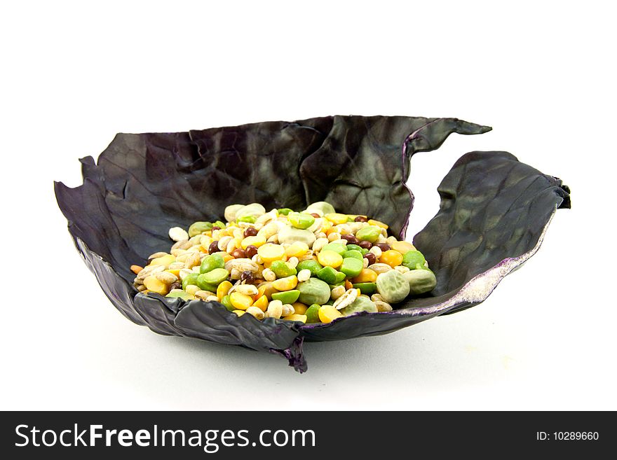 Pile of soup pulses in a red cabbage leaf on a white background. Pile of soup pulses in a red cabbage leaf on a white background