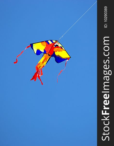 A colorful kite soaring in the blue sky