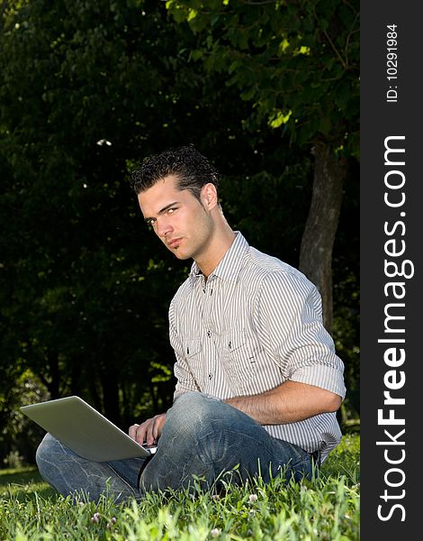 Serious businessman working with his laptop in the park. Serious businessman working with his laptop in the park