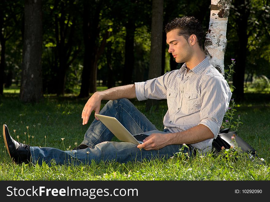 Businessman working with his laptop in the park. Businessman working with his laptop in the park