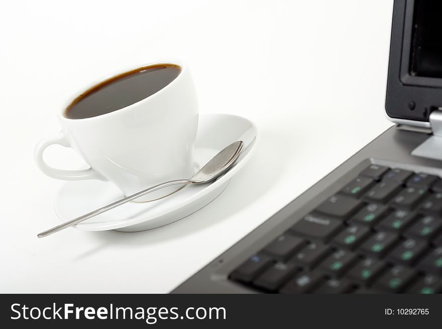 A cup of coffee and laptop on white background