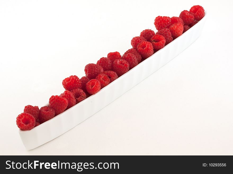 Red raspberries in a white bowl
