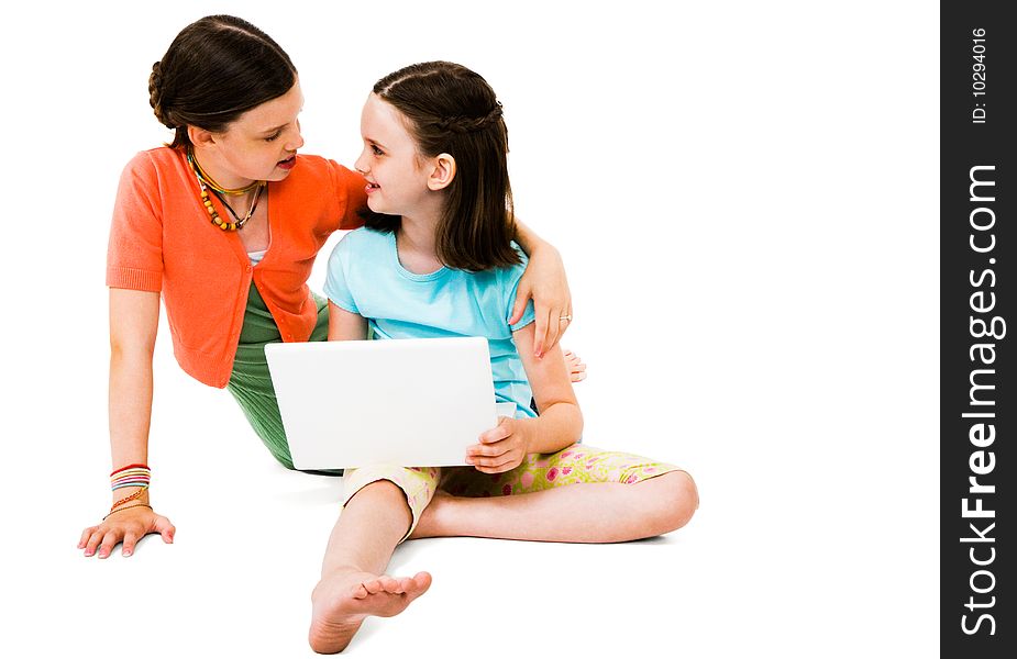 Smiling girls using a laptop isolated over white