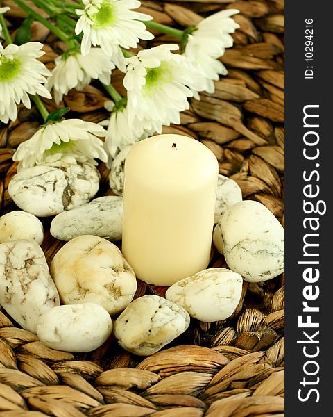 Spa concept. Candle, stones and white flowers.