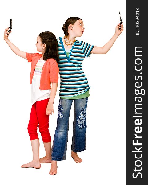 Two girls photo messaging on mobile phones isolated over white