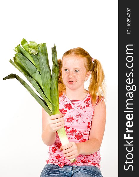 Girl is looking strange at leek isolated on a white background