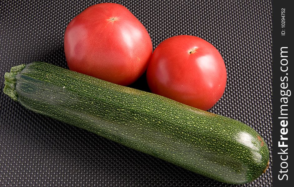 Two tomatoes and green zucchini. Two tomatoes and green zucchini